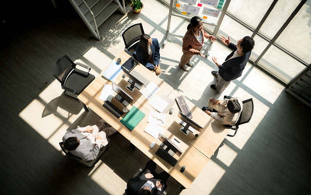 Overhead view of business professionals collaborating around office desks.