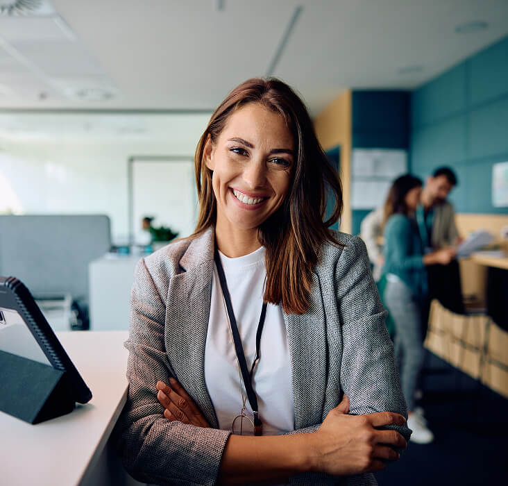 Smiling professional woman in a modern office, illustrating FINcredible career opportunities.