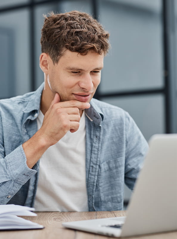 Man reviewing information on a laptop, illustrating digital banking and financial services.