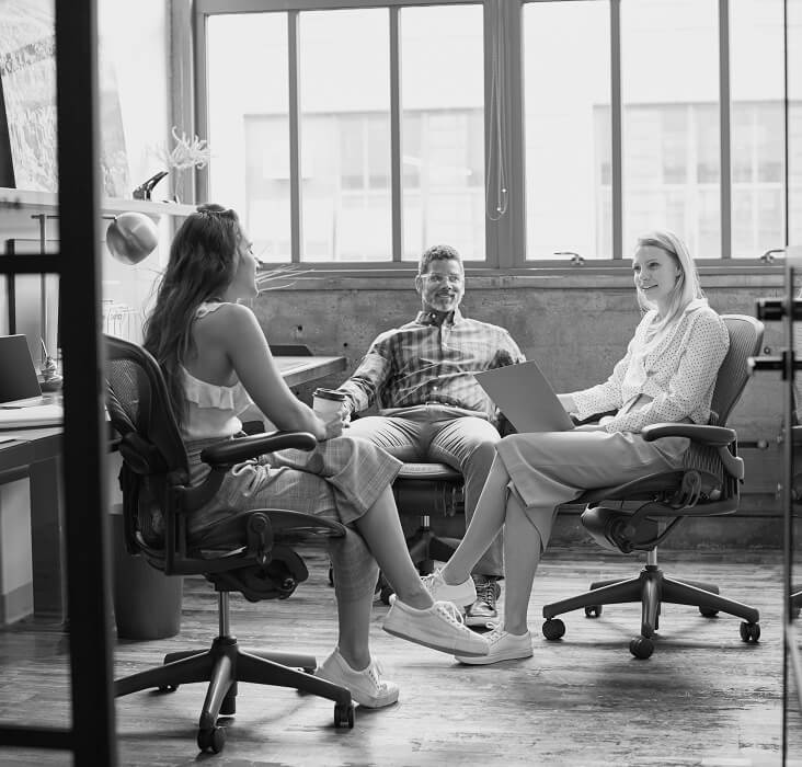 Three colleagues having a discussion in a modern office.