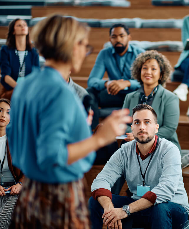Business professionals listening to a presenter during a conference or workshop.