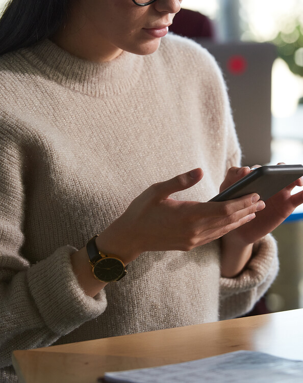 Woman holding a smartphone, illustrating secure digital authentication and data protection.